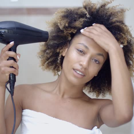 woman drying her hair with hairdryer