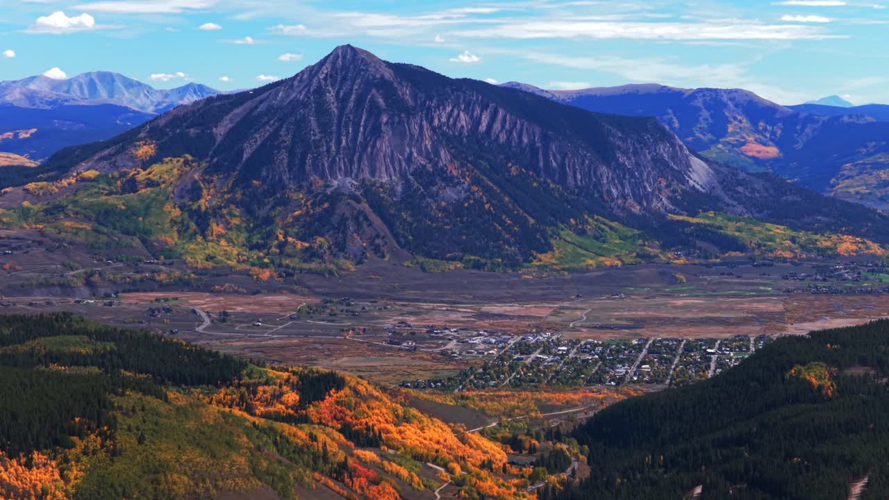 Crested Butte ski resort small Colorado Rocky Mountains down town Main Street drone aerial fall autumn Quaking Aspen Trees leaf peeping daytime blue skies clouds Coal Creek Kebler Pass forward pan up