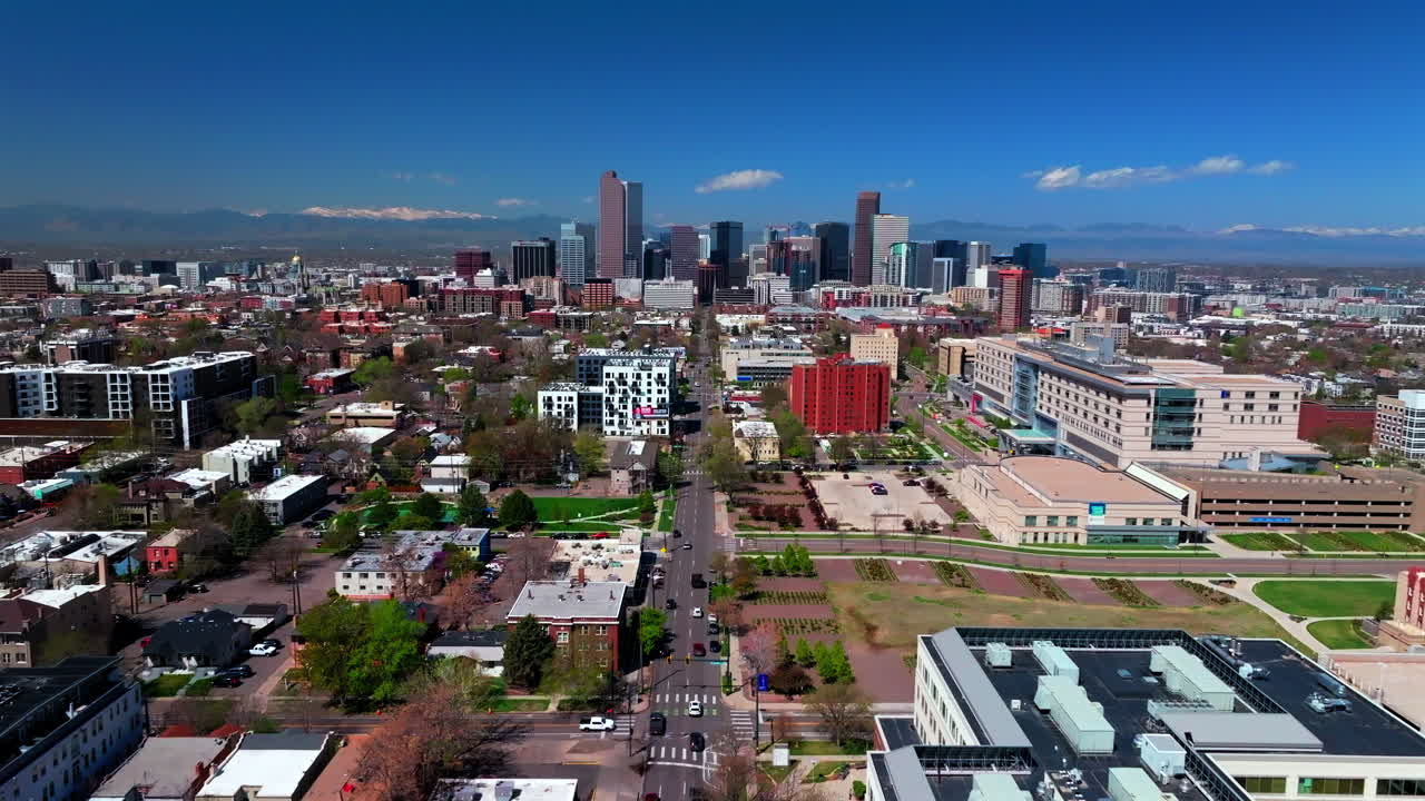 City Park Washington Park Denver spring summer aerial drone Colorado Front range Lodo Downtown cityscape Rocky Mountain street cars tall buildings skyscrapers sunny blue sky forward up motion