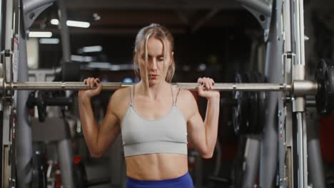 woman performing barbell back squat in gym