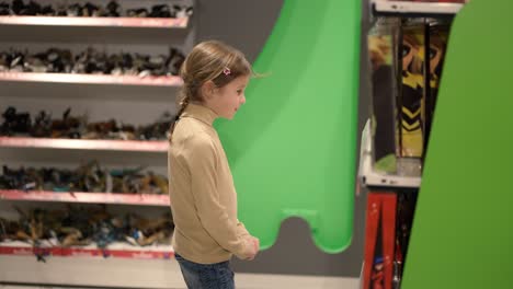 little girl is exciting with choosing toys boxes in the mall