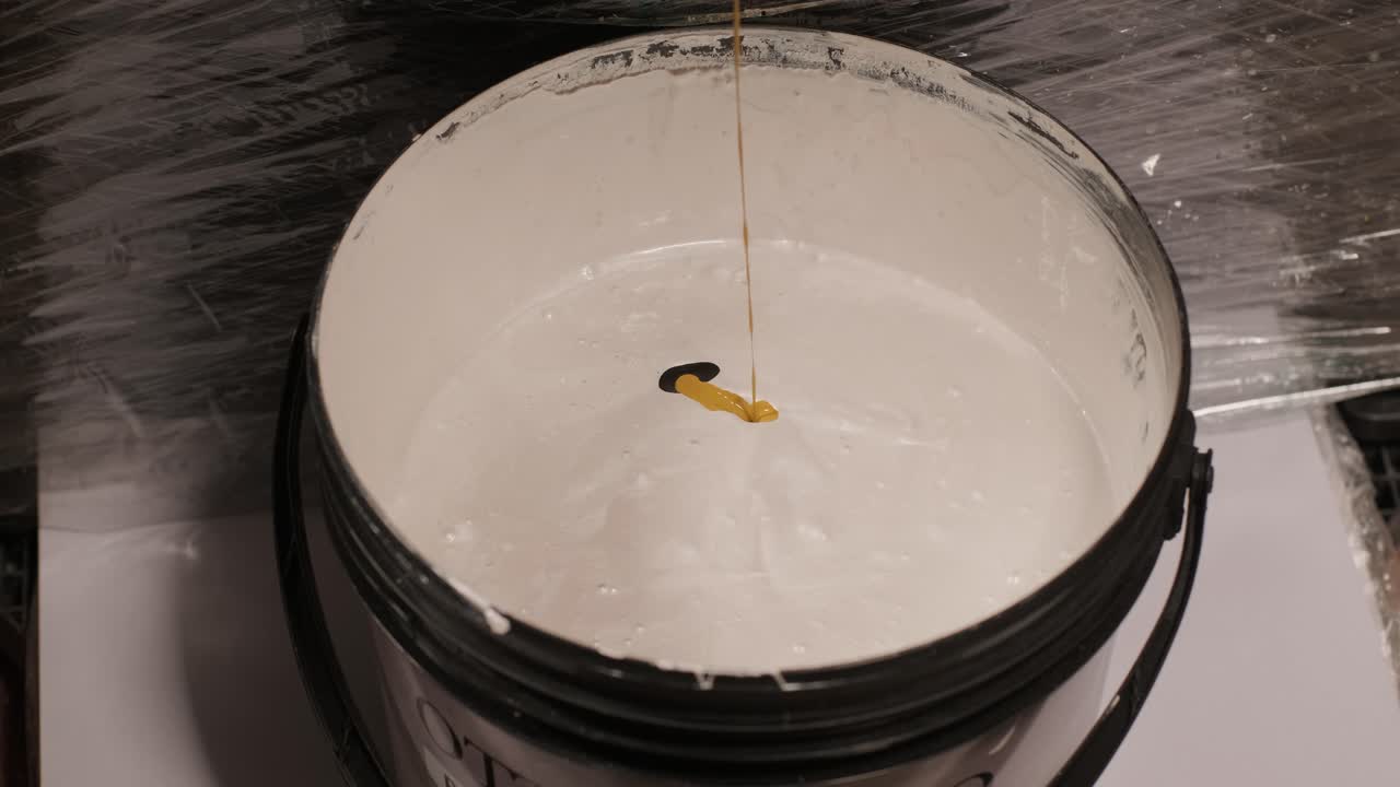 un trabajador mezcla el material para enmascarar las paredes