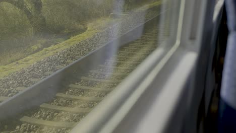 inside a moving german ice train, looking out at train tracks and passing scenery