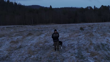 fosen indre, condado de trondelag, noruega - un hombre paseando a su perro alrededor de la granja en noviembre - disparo de seguimiento