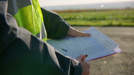 manager, high visibility jacket reading detailed work report