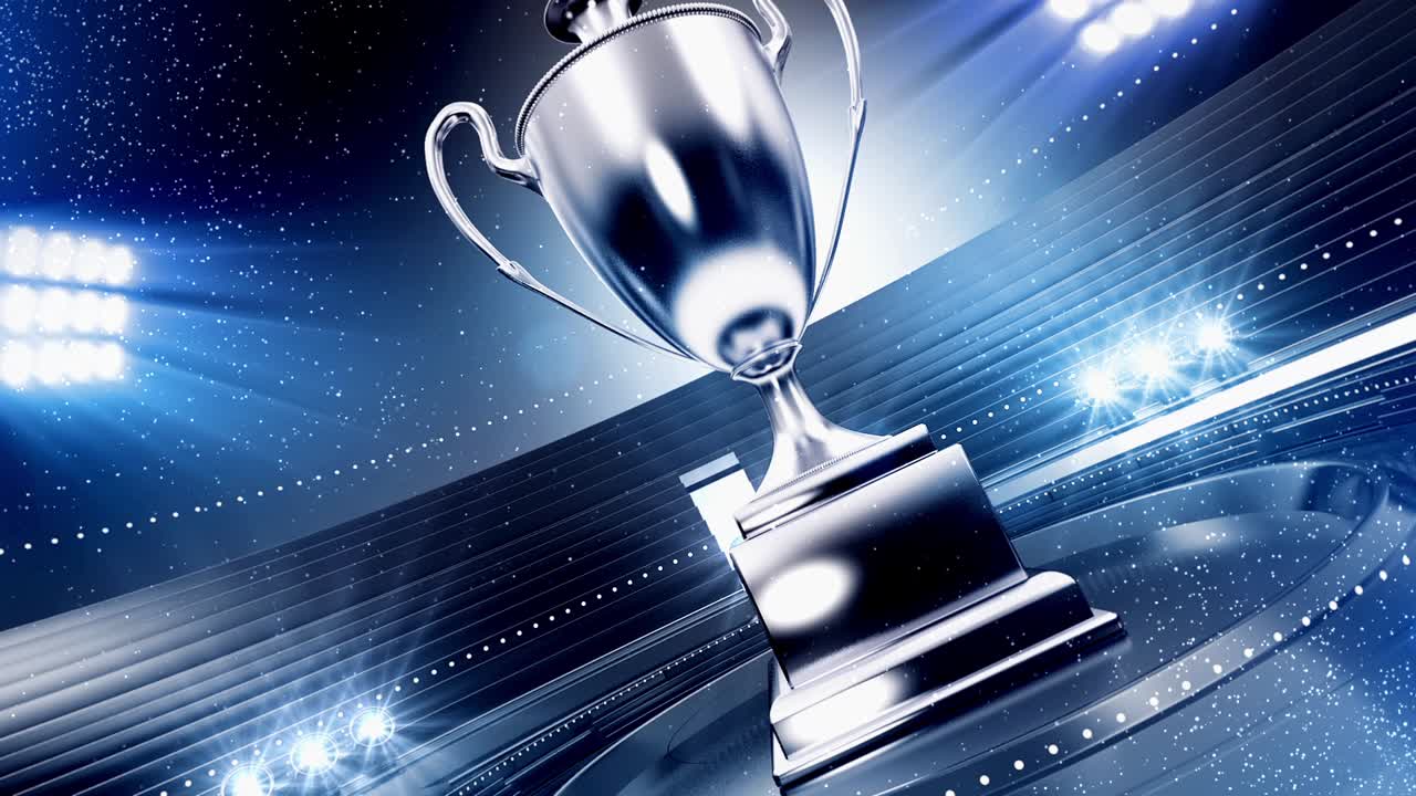 Trofeo d'argento rotante in uno stadio illuminato con particelle che cadono