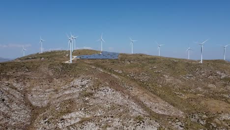 Luftpanoramaaufnahme-Des-Turbinenparks-Und-Der-Sonnenkollektoren-Auf-Dem-Grünen-Berg-Bei-Sonnenlicht