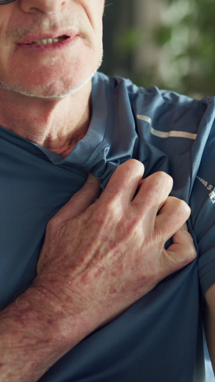 Senior Man Experiencing Chest Pain and Gripping His Shirt