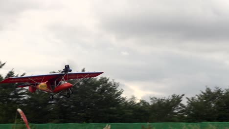 avión ultraligero triciclo de dos plazas despegando de la pista de aterrizaje