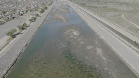 aerial shot of a river with a pan up revealing a bridge in costa mesa, california