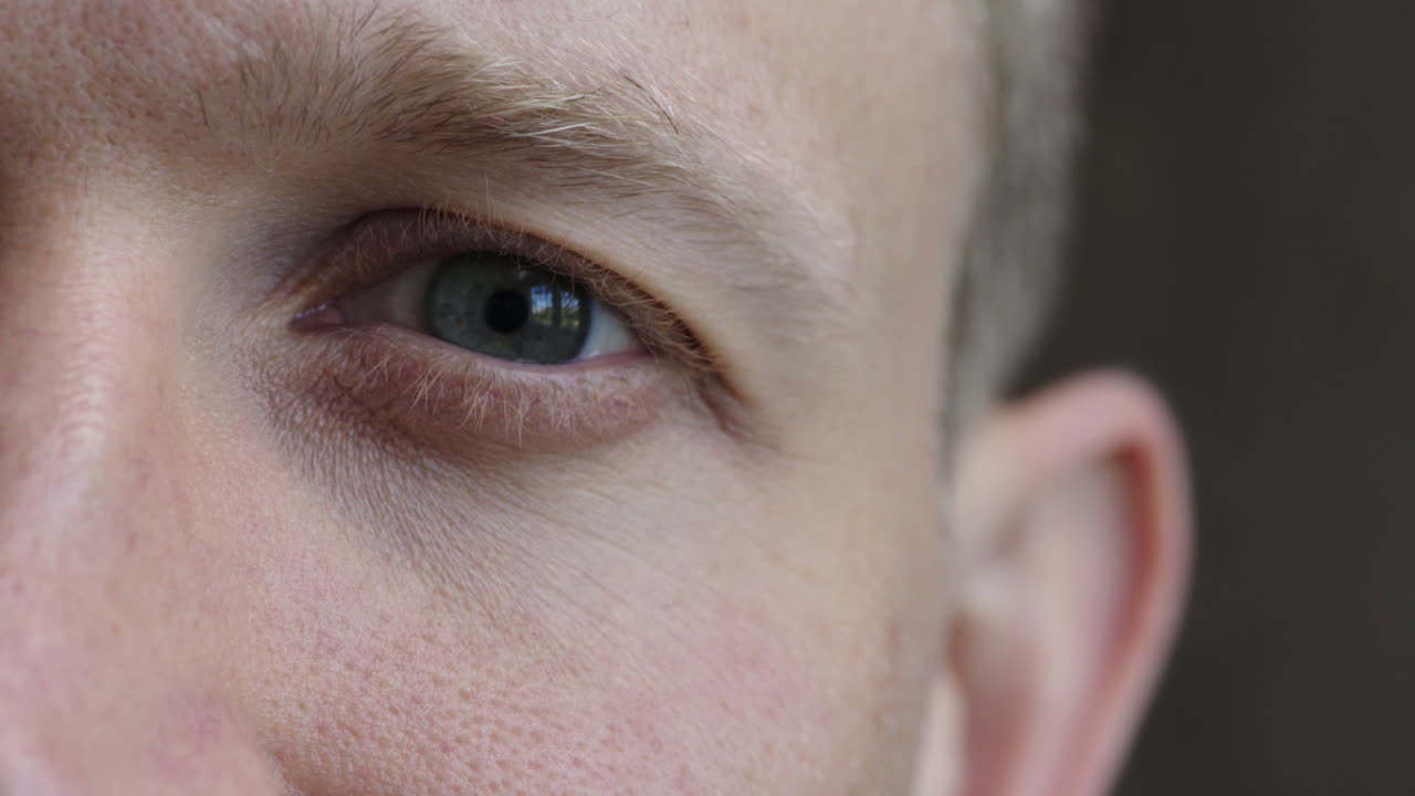 가까이서 남성 파란 눈이 열리고 눈을  ⁇ 박이고 깨어 있습니다.