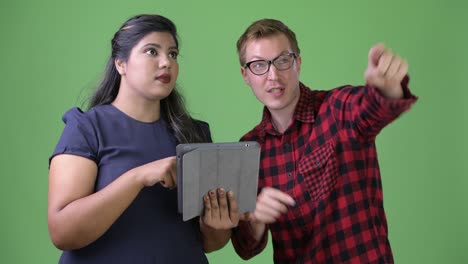 joven pareja de negocios multiétnica juntos contra un fondo verde