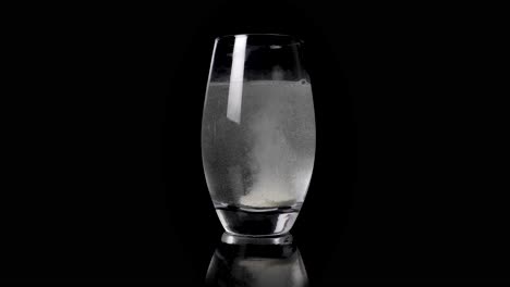 brausetablette aus magnesium, die sich in einem glas flüssigem wasser auflöst