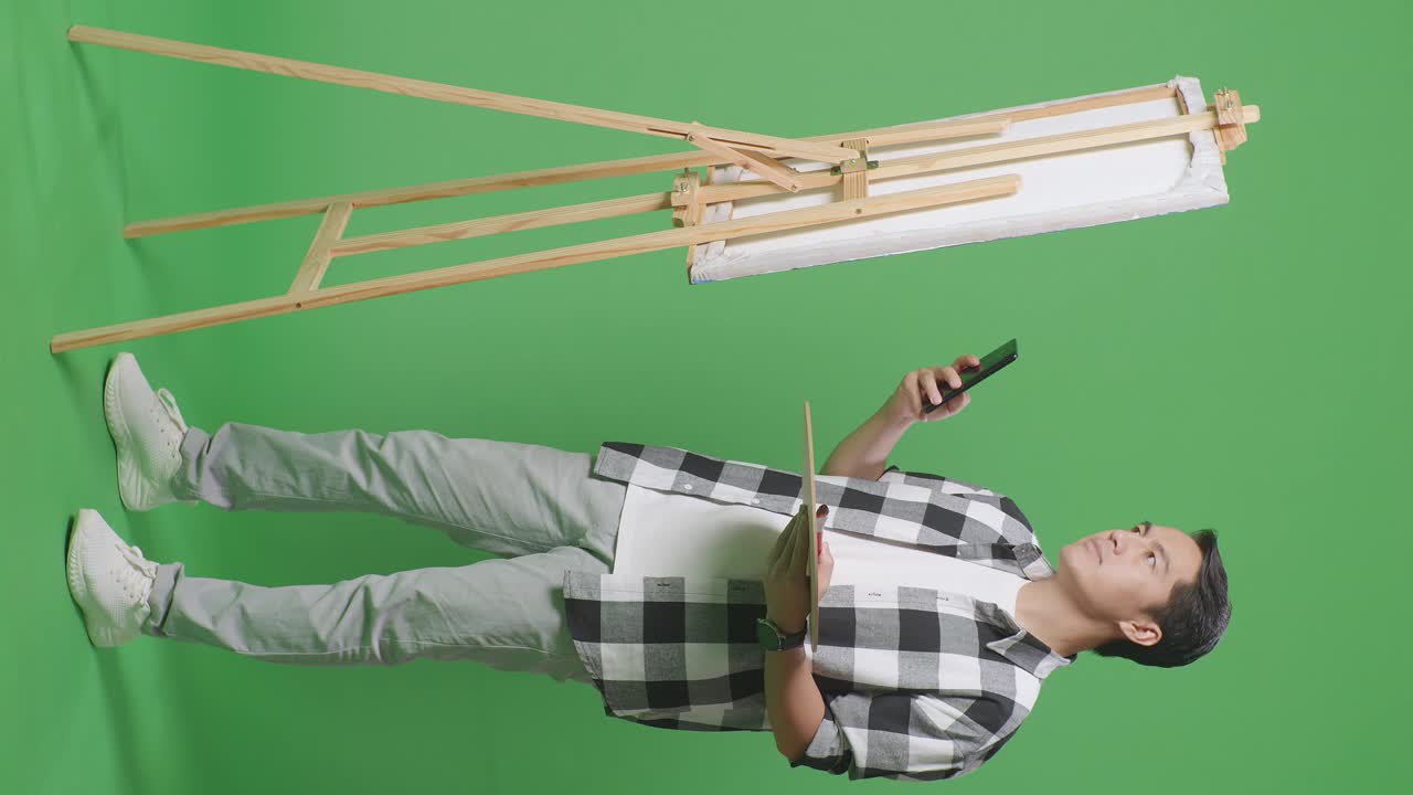 아티스트가 스 근처의 스마트폰에서 디지털 미술작품을 검토하고 있습니다.