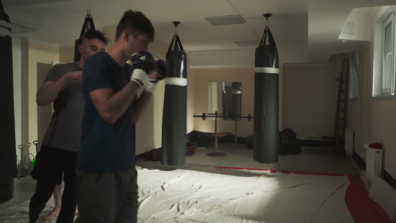 Sportsfolk løber rundt i boksehallen. Et kickbokserhold træner sammen på skøjtebanen i en kampklub i slowmotion. Mænd varmer op inden kamp indendørs