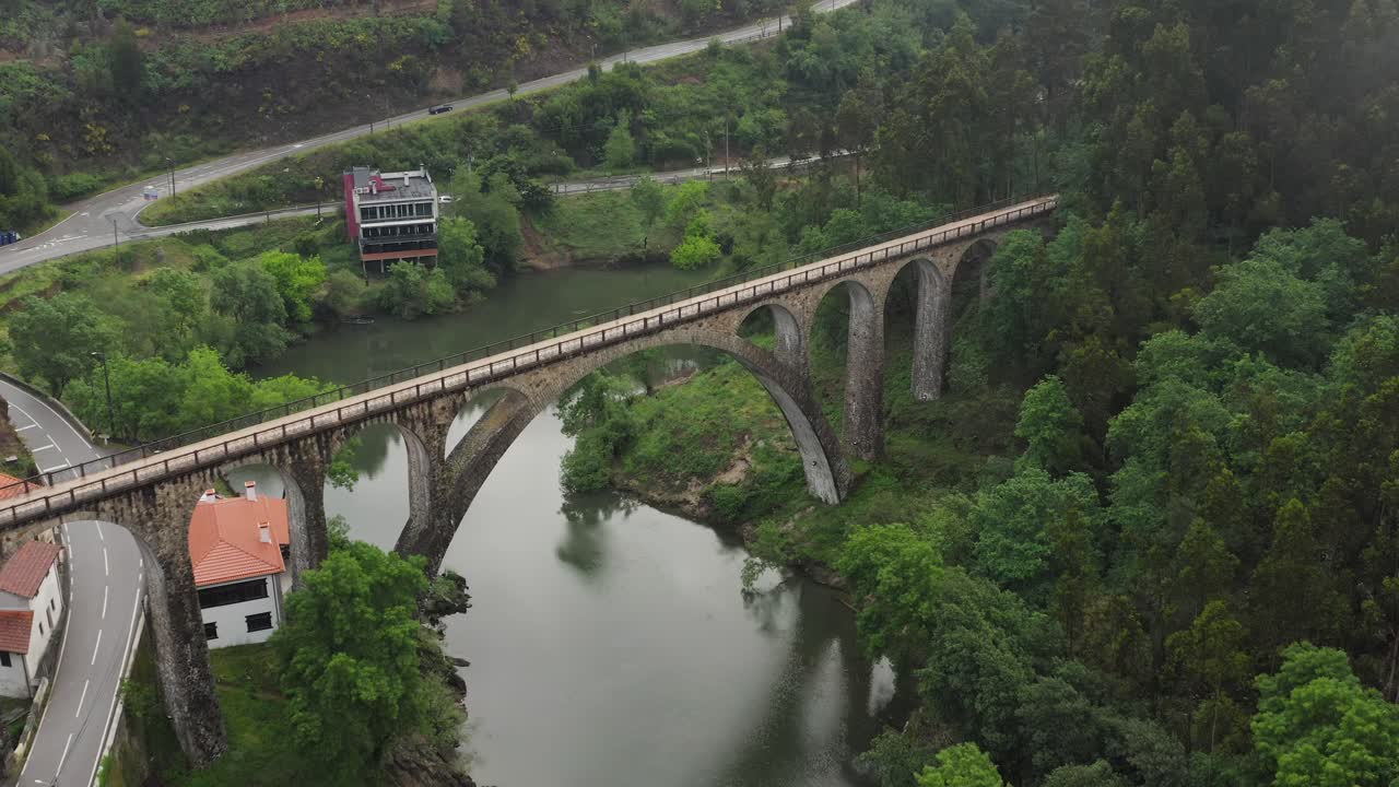 Aerial: Po&ccedil;o de Santiago Bridge over Serene Sever do Vouga River and Winding Road, Portugal