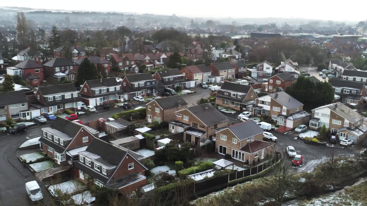 Snefyldt luftfoto af et boligområde i en landsby, vinterfrosne nordvestlige huse og veje driver til højre.