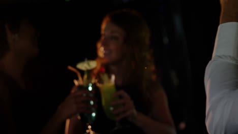 hermosa mujer joven interactuando mientras tiene un vaso de cóctel en el bar