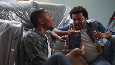 black builders eat pizza with beer tell jokes sit on floor