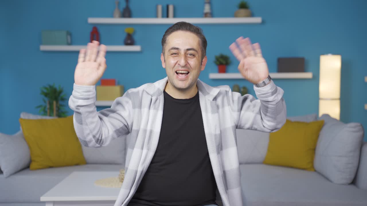 카메라를 향해 손을 흔드는 행복한 남자.