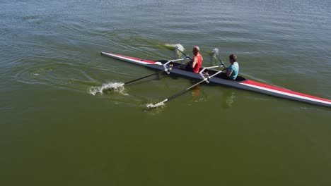 senior caucasian man and woman rowing boat on a river