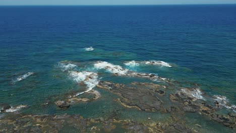 waves crashing on the rocky coastline of chania in crete island, greece. - aerial shot