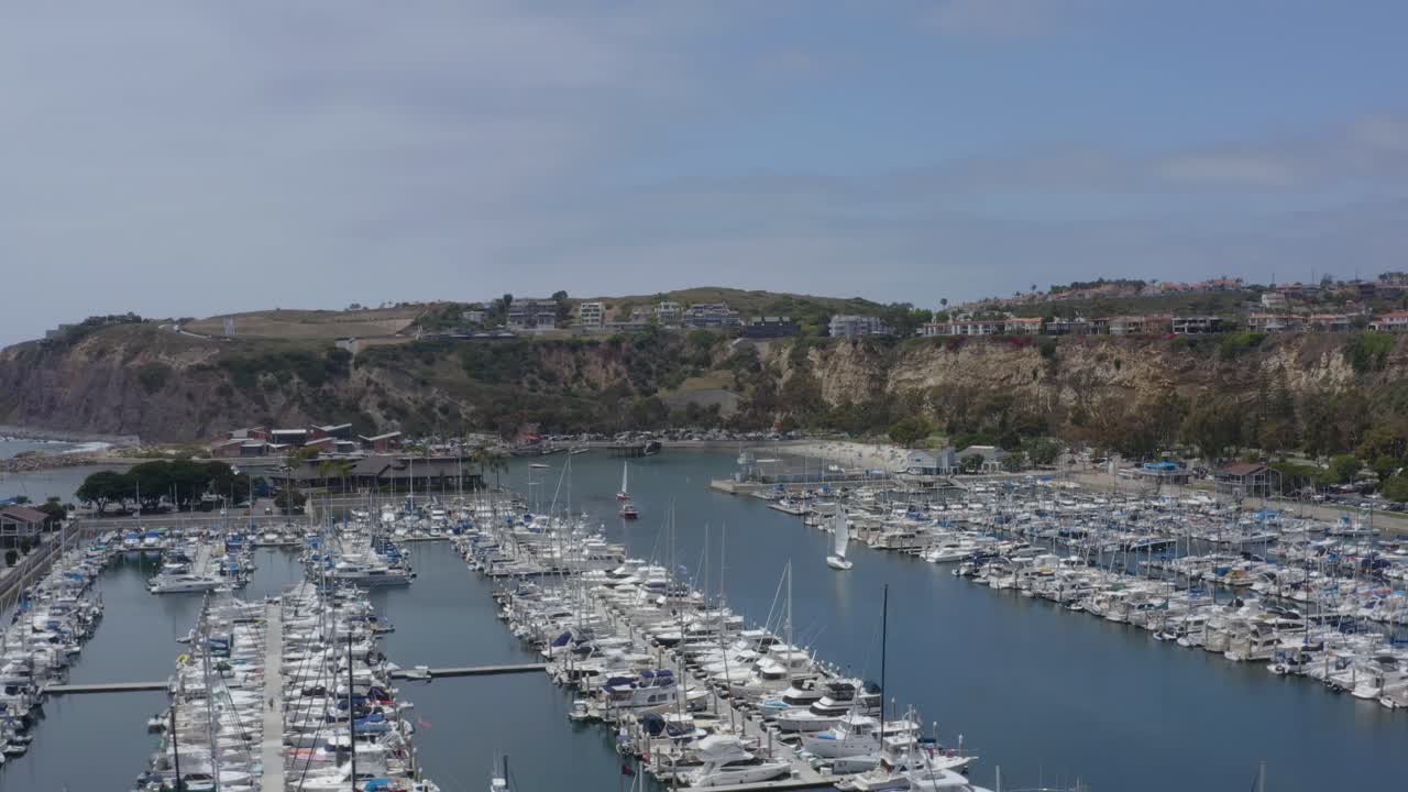 un hermoso avión no tripulado con vista aérea, volando sobre el puerto de dana point hacia los acantilados, dana point - condado de orange - california
