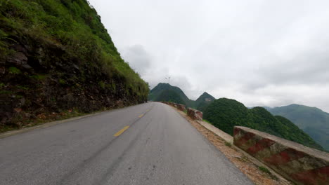 pov of a scooter rider traveling through hillside road in vietnam.