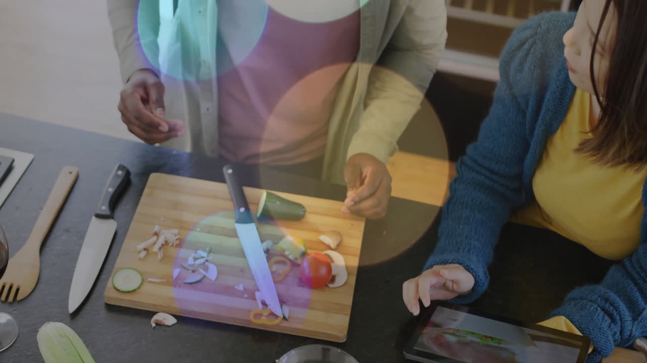 Cooking vegetables on cutting board with colorful light circles in kitchen scene