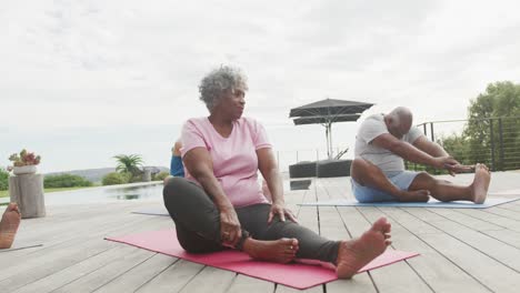 senior diverse people practicing yoga in garden at retirement home