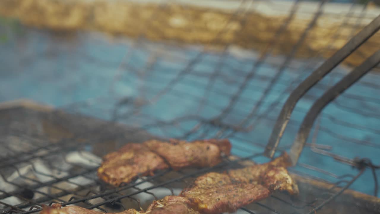 숯불 바비큐 그릴 위에 집게로 익힌 쇠고기를 들고 다시 내려놓기