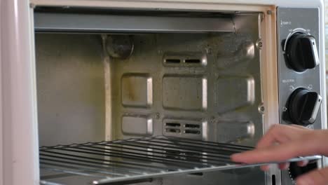 inserting the cake tray into the oven