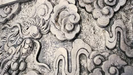 intricate stone carving design at the ancient temple wall in bai dinh pagoda tower at the province of ninh binh, vietnam. - panning shot