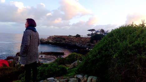 women looking out over ocean at lookout point searching for whales in hermanus