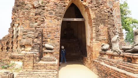 persona entra en la pagoda con la estatua de buda