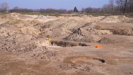 establishing, static view of mounds of dirt, holes at archaeology site