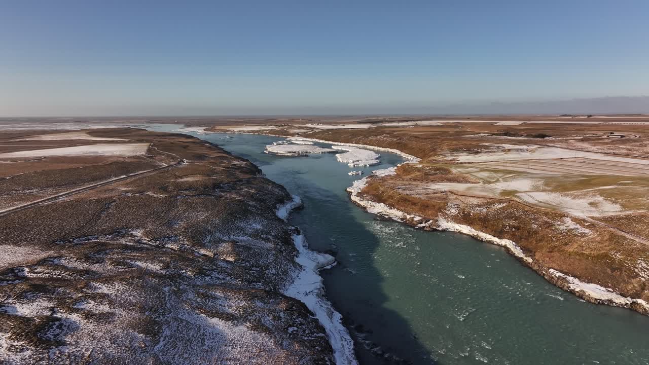 The icy river leading towards urriðafoss waterfall, iceland, aerial view