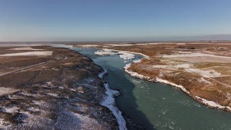 the icy river leading towards urriðafoss waterfall, iceland, aerial view