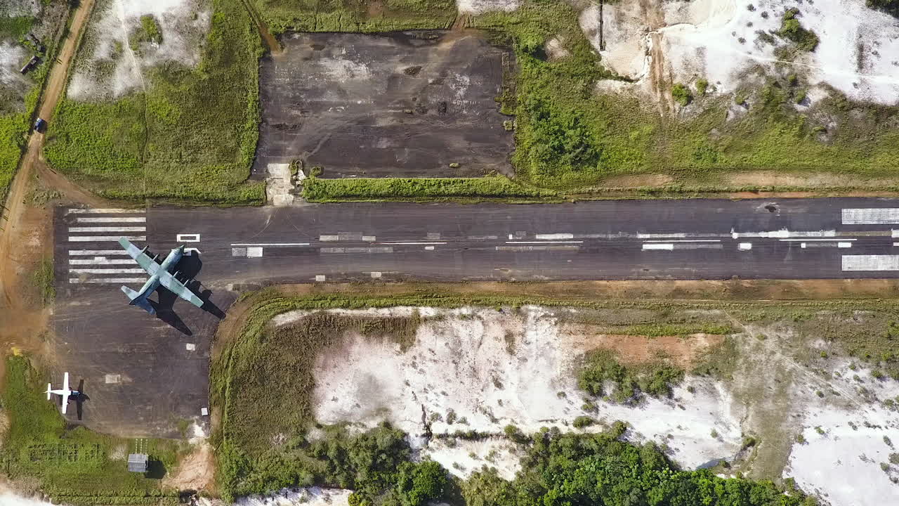 Top view aerial shot of a big military plain heading out to a runway to take off