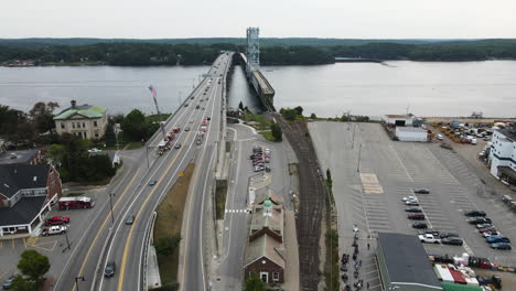 Vorwärtsdrohnenflug-Neben-Der-Route-1-In-Der-Stadt-Bath-Maine,-Der-Den-Fließenden-Verkehr-über-Die-Brücke-Zeigt