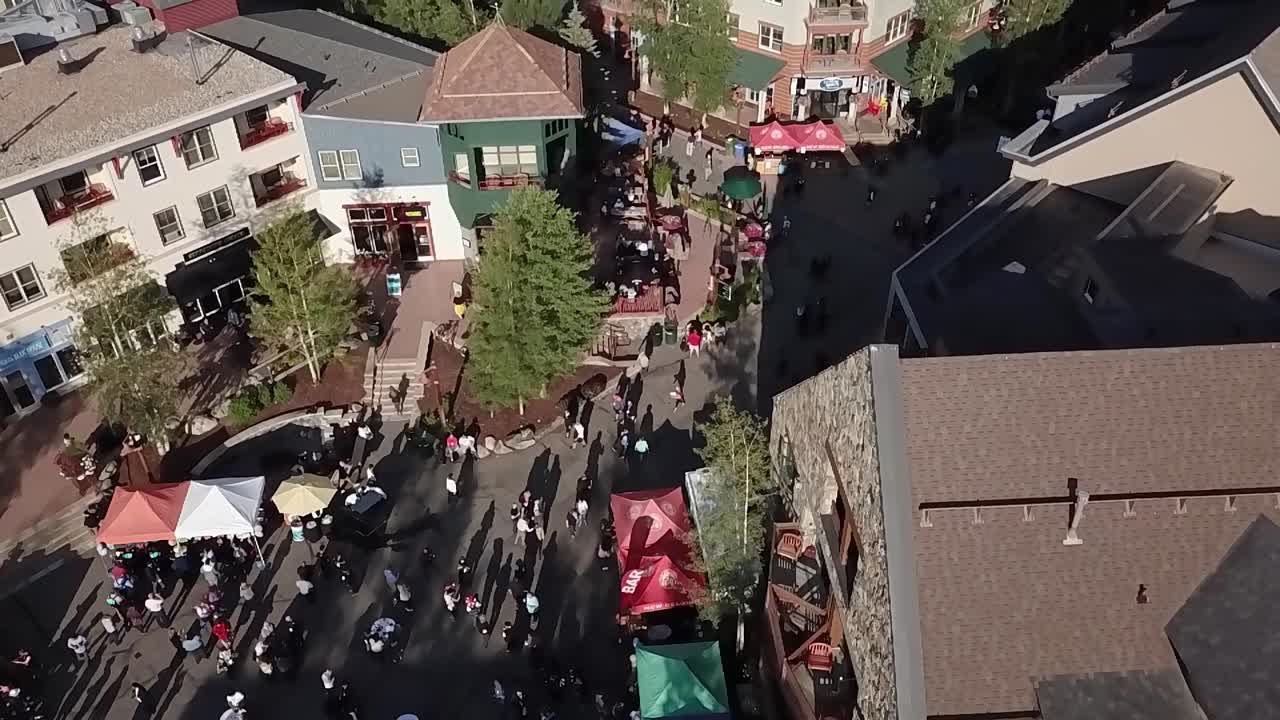 Aerial, drone shot overlooking people on the streets of the Keystone village, on a sunny day, in Summit County, Colorado, United States