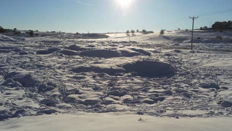 snow covered rural winter countryside track footprint shadows terrain aerial view dolly shot left