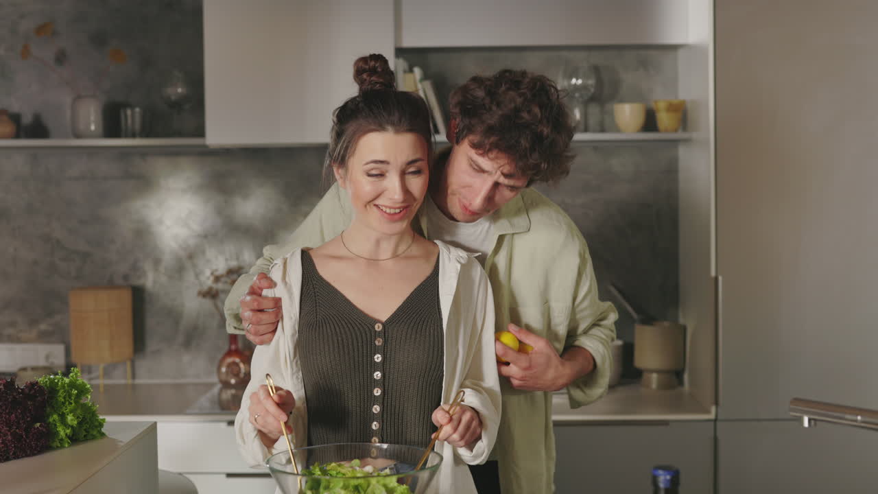 Una coppia che cucina e si abbraccia in una cucina moderna