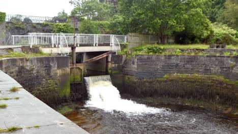 cascading river water flood gate channel control gateway vehicle passing over footbridge