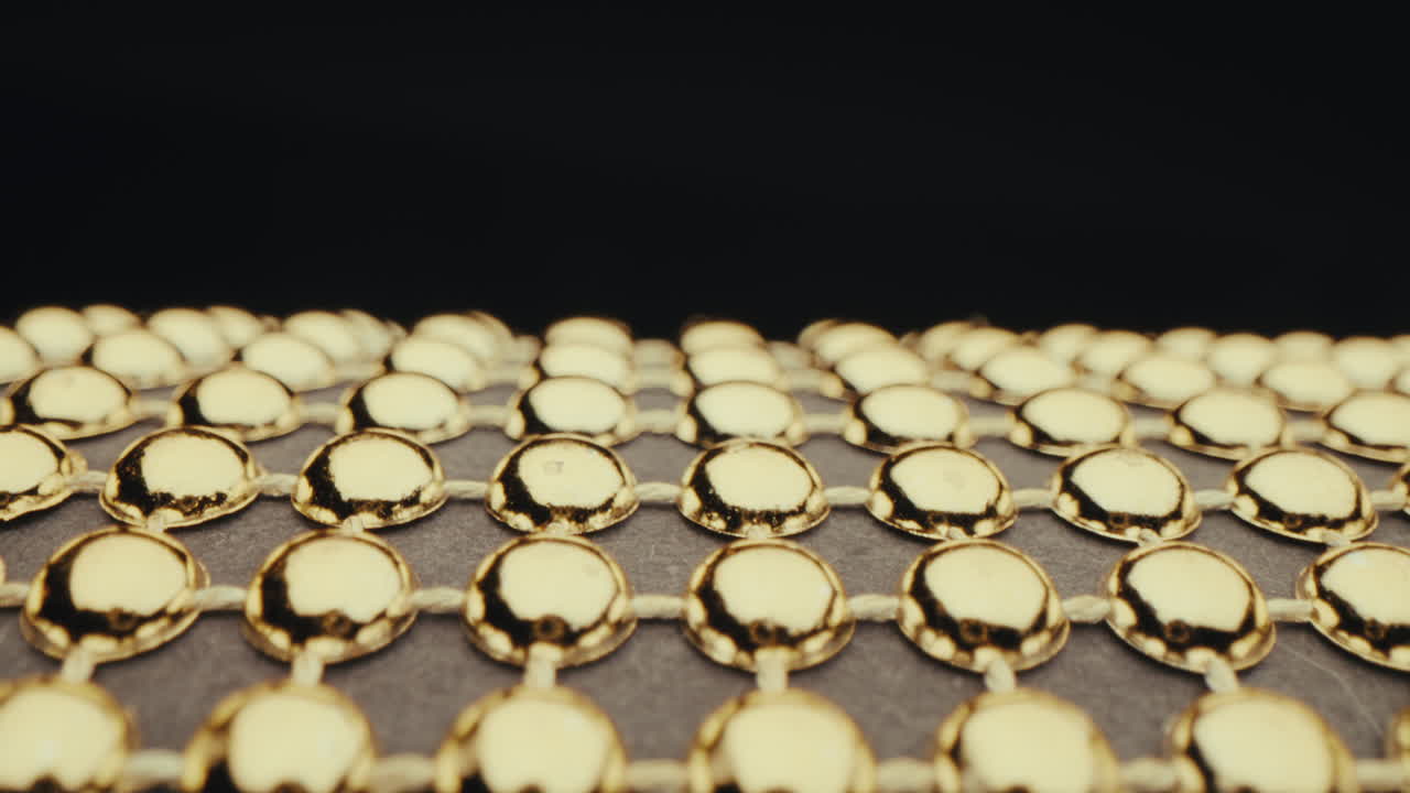 Close-up of Golden Beads on a Grid Pattern