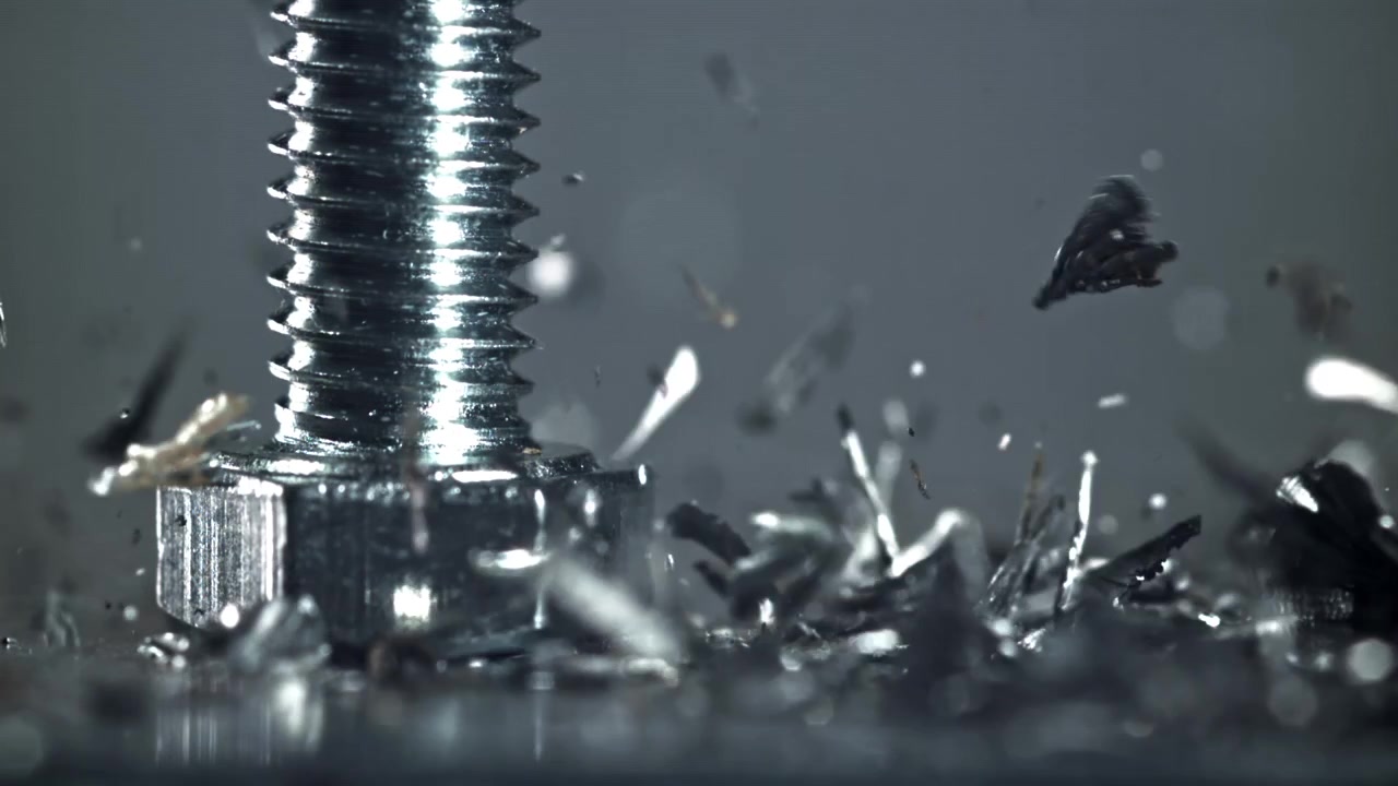 Slow Motion Macro Shot of Metal Shavings Falling Around a Screw