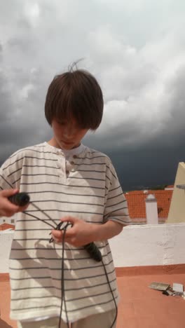 boy jumping rope on rooftop