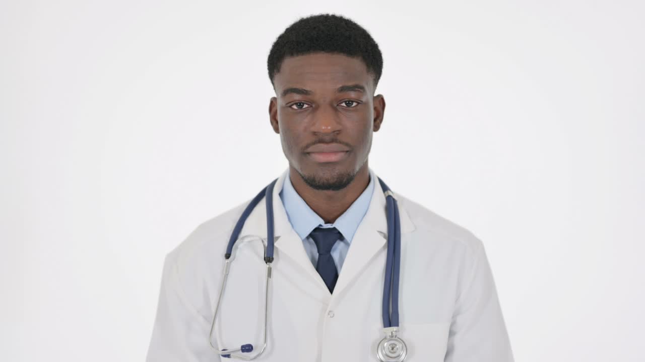 Medico africano serio che guarda la telecamera su sfondo bianco