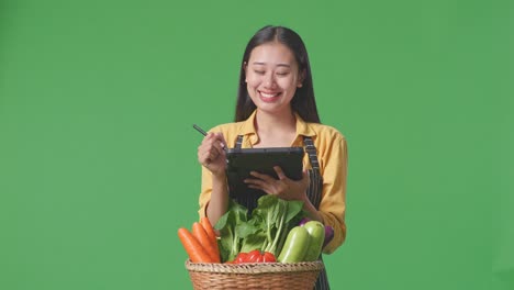 woman farmer checking vegetables in market