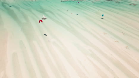 Drone-shot-of-kitesurfers-gliding-over-shallow-waters
